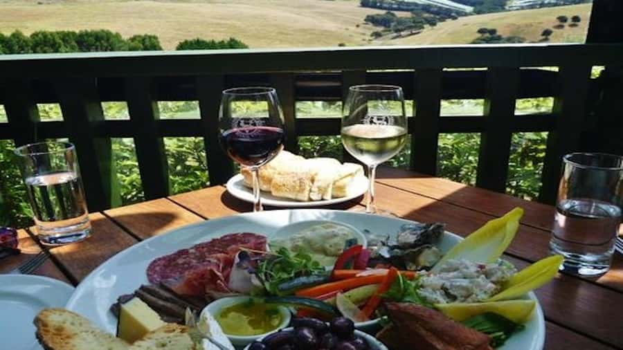 Waiheke: Scenic Taste and Graze Tour with Wine, Whisky, Beer - Mudbrick Restaurant and Vineyard wine tasting with Rangitoto in view